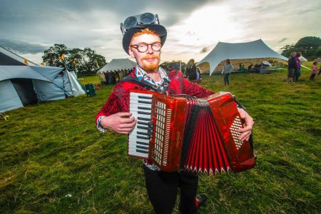 Musician plays accordion outside big top