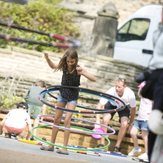young girl spins a hula hoop