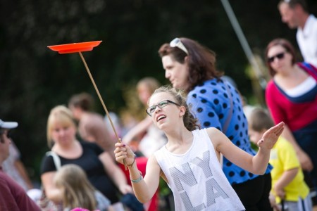 girl spins plate on a stick