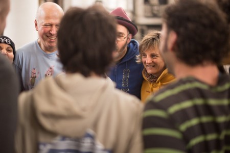 A group of adults smile at the end of a team building workshop